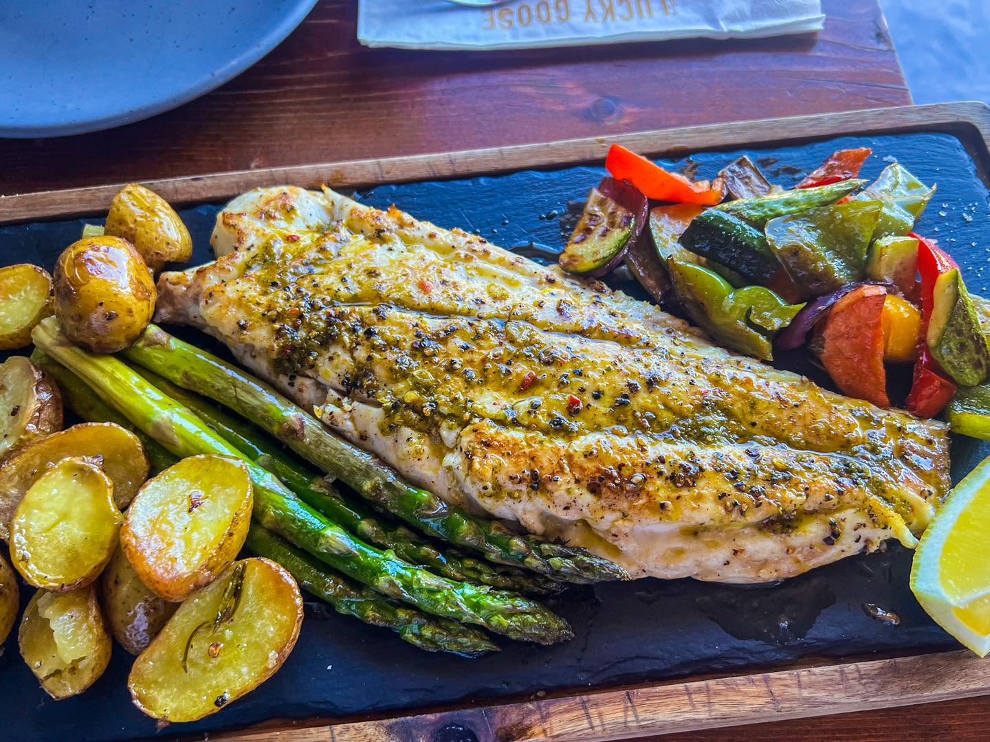Grilled fish served with potatoes and vegetables