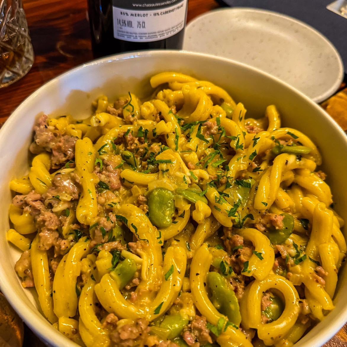 A bowl of pasta with herbs and vegetables